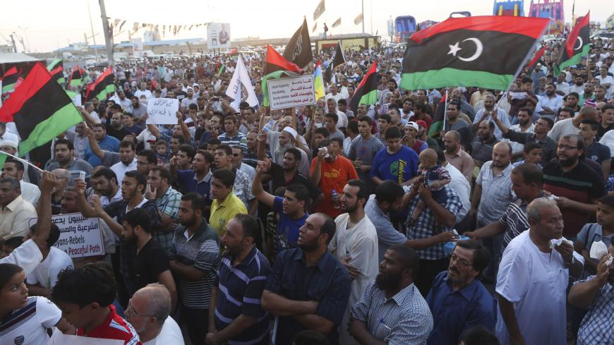 Demonstrators gather to protest against the Libyan Parliament's decision to call on the United Nations and the Security Council to immediately intervene to protect civilians and state institutions in Libya, at Freedom Square in Benghazi August 15, 2014. The new U.N. special envoy to Libya, Bernardino Leon, plans to visit Tripoli as early as next week to seek a ceasefire between armed factions whose clashes have turned parts of the capital into a battlefield, his office said.  REUTERS/Esam Omran Al-Fetori (L