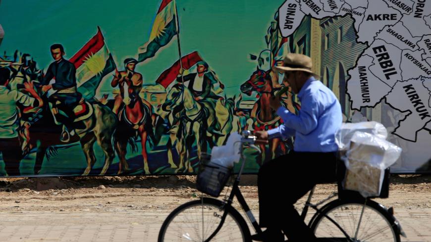A man rides a bike near a mural supporting the referendum for independence of Kurdistan in Erbil, Iraq September 24, 2017. REUTERS/Alaa Al-Marjani     TPX IMAGES OF THE DAY - RC12B8261980