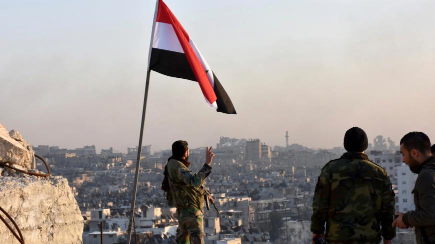 A Syrian government soldier gestures a v-sign under the Syrian national flag near a general view of eastern Aleppo after they took control of al-Sakhour neigbourhood in Aleppo, Syria in this handout picture provided by SANA on November 28, 2016. SANA/Handout via REUTERS ATTENTION EDITORS - THIS IMAGE WAS PROVIDED BY A THIRD PARTY. EDITORIAL USE ONLY. REUTERS IS UNABLE TO INDEPENDENTLY VERIFY THIS IMAGE. - RC14B3B13650