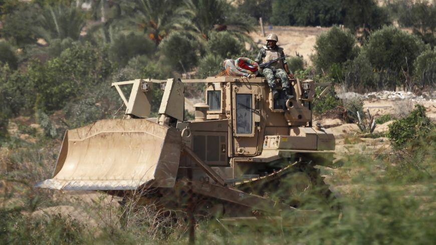 An Egyptian soldier sits atop a bulldozer on the border between Egypt and southern Gaza Strip September 12, 2013. Cairo closed the Rafah crossing, Gaza's main window to the world, completely on Wednesday after assailants crashed two explosive-laden cars into a security building adjacent to the border zone, killing six Egyptian soldiers. The bulldozing of the tunnels has deepened Gaza residents' feelings of isolation in a tiny coastal territory that many have described as a prison. Egypt has suggested Palest