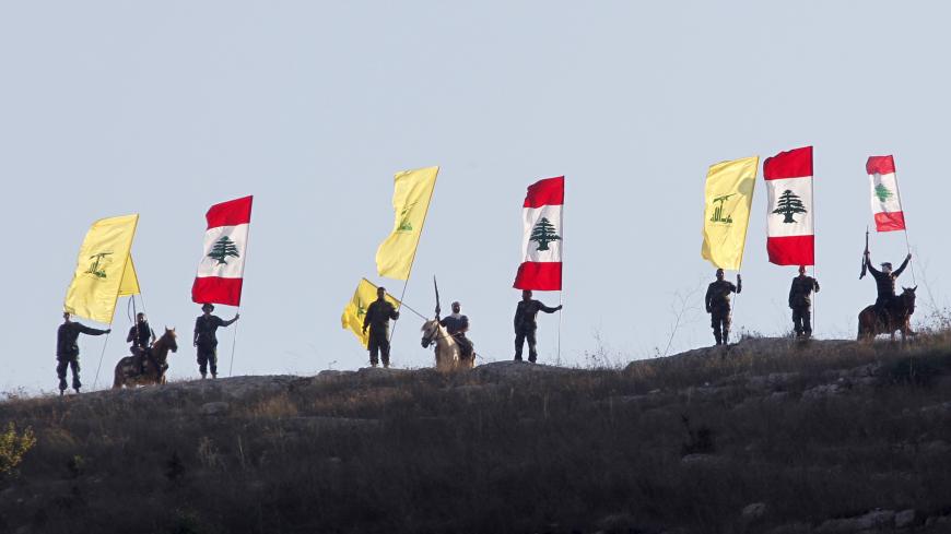 Members of Lebanon's Hezbollah wave Hezbollah and Lebanese flags during a rally marking the ninth anniversary of the end of Hezbollah's 2006 war with Israel, in Wadi al-Hujeir, southern Lebanon August 14, 2015. REUTERS/Aziz Taher - GF10000174101