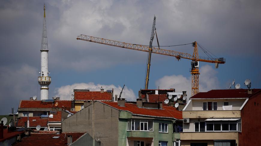 A construction crane is seen behind residential buildings in Istanbul, Turkey May 24, 2017. REUTERS/Murad Sezer - RC1178F41100
