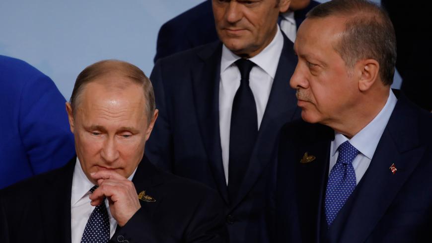 Russian President Vladimir Putin looks on next to European Council President Donald Tusk and Turkish President Recep Tayyip Erdogan at the G20 summit in Hamburg, Germany July 7, 2017. REUTERS/Carlos Barria - RC1D608EC340