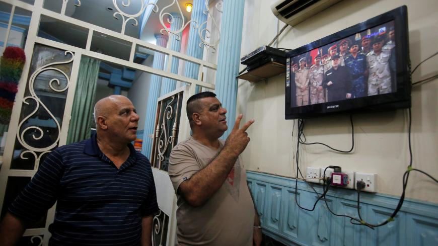 Iraqi men watch television as Iraqi Prime Minister Haider al-Abadi announces victory over Islamic State in Mosul, in Baghdad, Iraq, July 10, 2017. REUTERS/Khalid al Mousily - RC125B78B700
