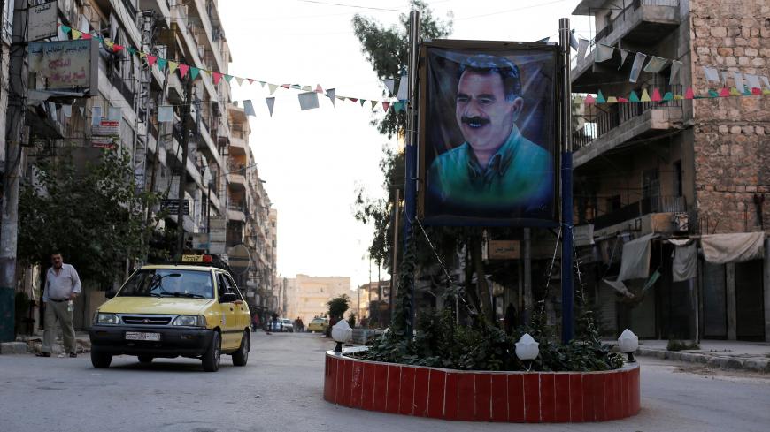 A car passes by a picture of the Kurdish leader Abdullah Ocalan of the Kurdistan Workers Party (PKK) in Aleppo's Sheikh Maqsoud neighbourhood, Syria July 15, 2017. Picture taken July 15, 2017. REUTERS/Omar Sanadiki - RC1F9BDFCDB0