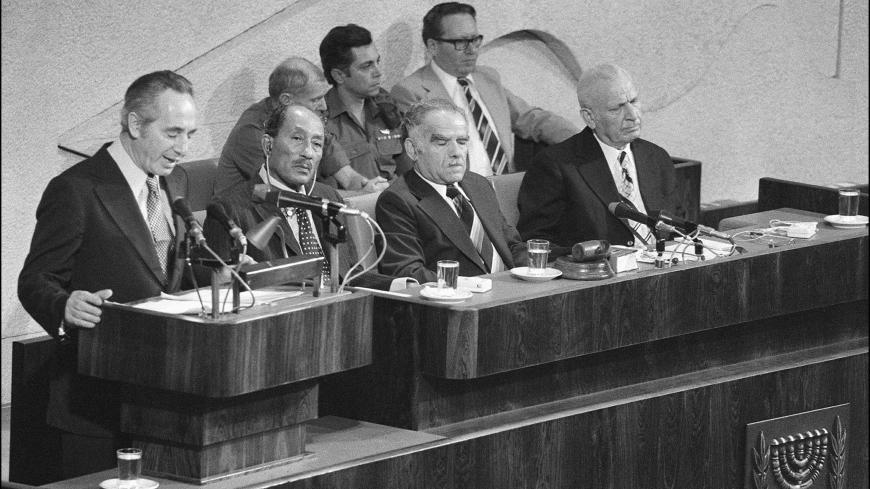 (FILES) Israeli Labor party leader Shimon Peres (l) addresses 20 November 1977 in Jerusalem the Knesset (parliament) as Egyptian President Anwar al-Sadat (c) and Israeli Foreign minister Yitzhak Shamir (2nd-r) listen during Egypt's President historic visit to Israel. Talks between Sadat and Begin continued and after various delays an unexpected breakthrough occurred in September 1978 after talks at Camp David in the USA under the guidance of US President Carter, when Begin and Sadat signed two peace agreeme