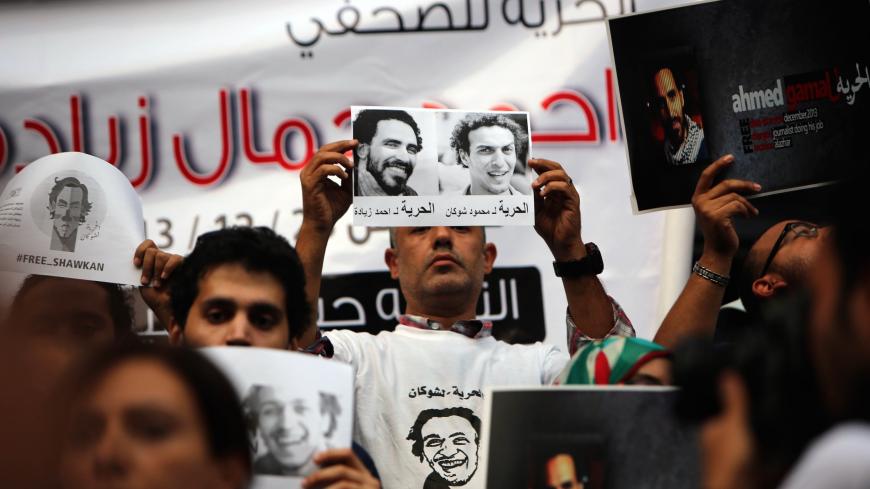 Egyptian journalists and photo-journalists take part in a protest in front of their syndicate in Cairo on September 30, 2014, to demand the release of their detained colleagues Mahmud Abu Zied (portrait-R), also known as Shawkan, and Ahmad Gamal (portrait-L). Since the army ousted Islamist president Mohamed Morsi in July 2013, political unrest has reached unprecedented levels in Egypt, with more than 1,400 people killed and at least 15,000 jailed in a government crackdown. AFP PHOTO/MOHAMED EL-SHAHED       