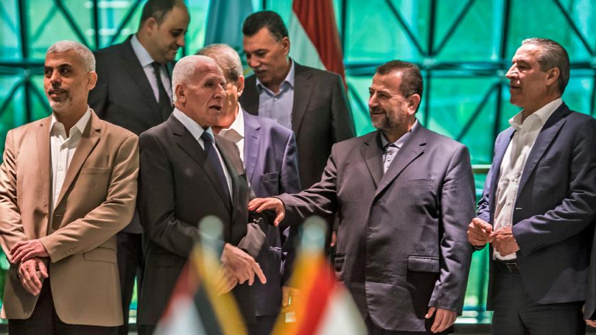 Fatah's Azzam al-Ahmad (C-L) speaks with Hamas' Saleh al-Aruri (C-R) after signing a reconciliation deal in Cairo on October 12, 2017, as the two rival Palestinian movements ended their decade-long split following negotiations overseen by Egypt.
Under the agreement, the West Bank-based Palestinian Authority is to resume full control of the Hamas-controlled Gaza Strip by December 1, according to a statement from Egypt's government. / AFP PHOTO / KHALED DESOUKI        (Photo credit should read KHALED DESOUKI/
