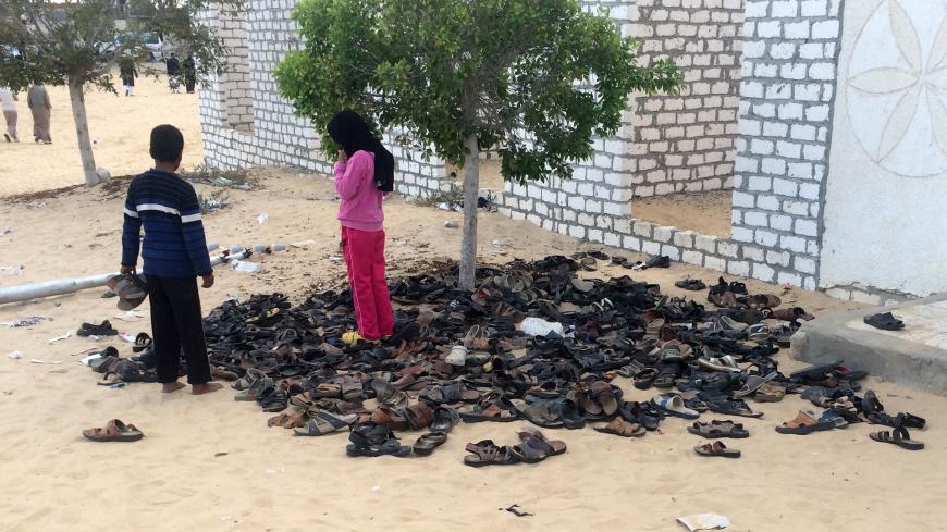 Egyptian children stand near a pile of footwear belonging to the victims of the attack that targeted the Rawda mosque near North Sinai provincial capital of El-Arish, on November 25, 2017.
Armed attackers killed at least 235 worshippers in a bomb and gun assault on the packed mosque in Egypt's restive North Sinai province, in the country's deadliest attack in recent memory.   / AFP PHOTO / STR        (Photo credit should read STR/AFP/Getty Images)