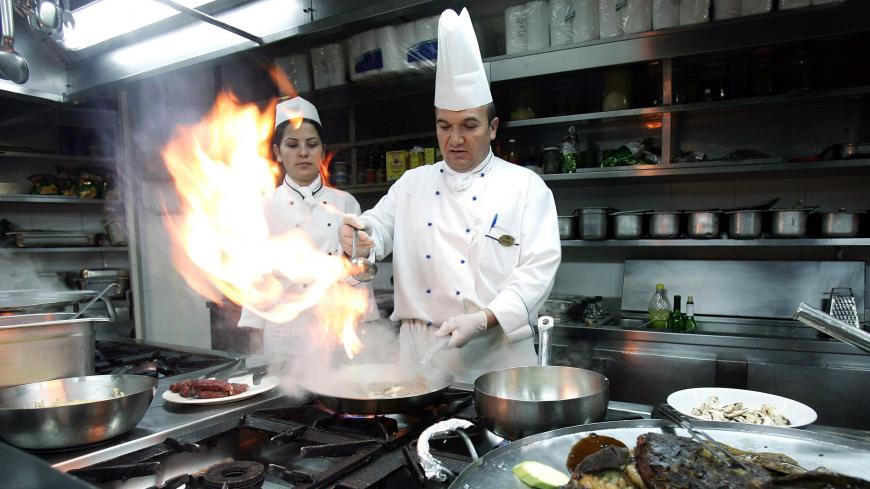 A Turkish cook prepares a beef steak on fire at a restaurant in a five-star hotel in the Mediterranean Turkish city of Antalya, January 17, 2006. Turkey's top holiday destination Antalya is concerned by the westward spread of the bird flu disease towards the city blessed by a long Mediterranean coast. Photo taken January 17, 2006. REUTERS/Umit Bektas - RP3DSFDNCIAC