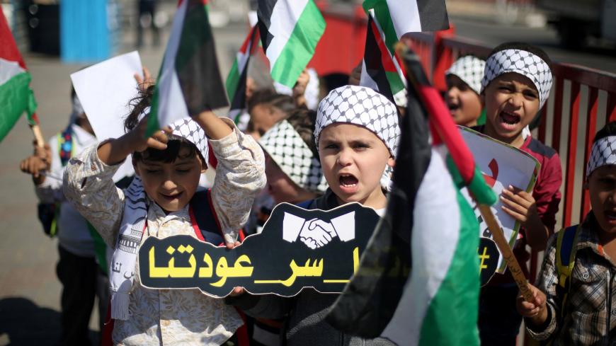 Children hold Palestinian flags as they celebrate after rival Palestinian factions Hamas and Fatah signed a reconciliation deal, in the central Gaza Strip October 12, 2017. Picture taken October 12, 2017. REUTERS/Ibraheem Abu Mustafa - RC17AA0B40E0