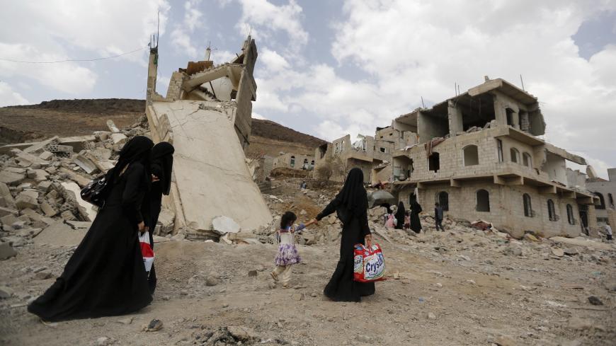 Women walk past a collapsed roof of a building destroyed by a Saudi-led air strike in Yemen's capital Sanaa September 7, 2015. Jets belonging to a Saudi-led coalition killed at least 20 people at a wake in northern Yemen on Sunday, local tribesmen said, as warplanes pounded Houthis and other forces behind a missile strike that had killed dozens of Gulf Arab soldiers. REUTERS/Khaled Abdullah - GF10000196256