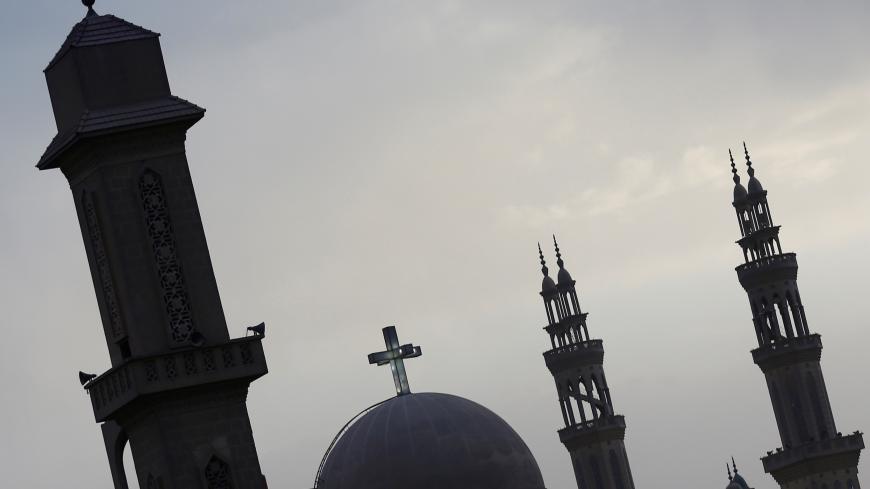 Minarets of a mosque and the cross above a church are seen at the agricultural road which leads to the capital city of Cairo, Egypt, April 11, 2017. REUTERS/Amr Abdallah Dalsh - RC11420D7D70