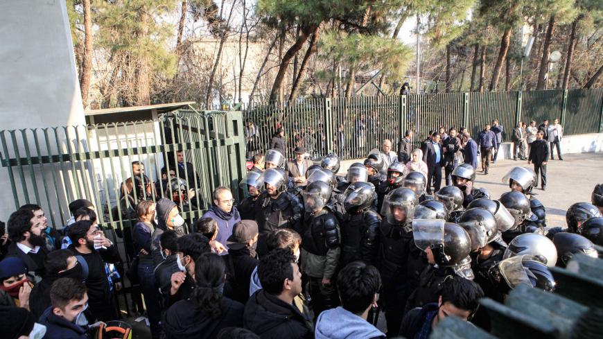 Iranian students scuffle with police at the University of Tehran during a demonstration driven by anger over economic problems, in the capital Tehran on December 30, 2017. 
Students protested in a third day of demonstrations, videos on social media showed, but were outnumbered by counter-demonstrators.  / AFP PHOTO / STR        (Photo credit should read STR/AFP/Getty Images)