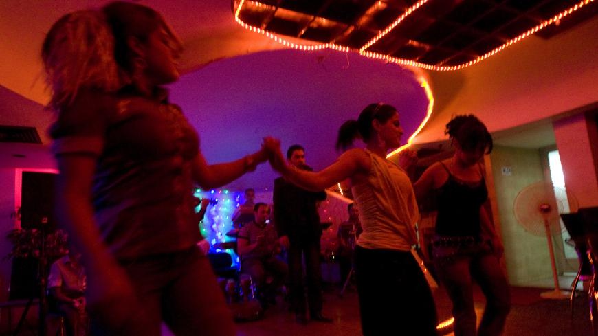 Women dancers perform at a nightclub in Baghdad July 9, 2009. As the worst of the violence unleashed in 2003 has faded, a buzzing nightlife has returned to the Iraqi capital. Some 17 nightclubs have opened in Baghdad, most featuring provocative dancers, suggestive music and ample booze. Picture taken July 9, 2009.  REUTERS/Thaier al-Sudani (IRAQ SOCIETY) - GM1E57F1OQY01