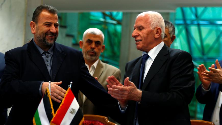 Head of Hamas delegation Saleh Arouri and Fatah leader Azzam Ahmad sign a reconciliation deal in Cairo, Egypt, October 12, 2017. REUTERS/Amr Abdallah Dalsh - RC12DBB41E80