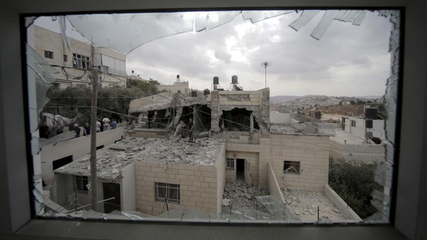 Palestinians stand on the razed home of a Palestinian militant in Jabel Mukaber, in an area of the West Bank that Israel captured in a 1967 war and annexed to the city of Jerusalem, October 6, 2015. Israeli forces destroyed the homes of two Palestinian militants and sealed off part of a third in Jerusalem on Tuesday, in a crackdown launched by Prime Minister Benjamin Netanyahu after four Israelis were killed in Palestinian attacks. The Israeli military said in a statement it had demolished the family home o