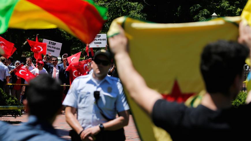 A group of pro-Erdogan demonstrators shout slogans at a group of anti-Erdogan Kurds (foreground, back to camera) in Lafayette Park as Turkey's President Tayyip Erdogan met with U.S. President Donald Trump nearby at the White House in Washington, U.S. May 16, 2017.  REUTERS/Jonathan Ernst - RC11DF991CB0