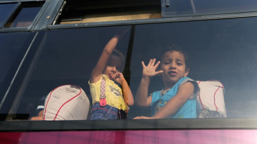 Palestinian children look out through a bus window as they wait with their family to cross into Egypt through the Rafah border crossing after it was opened by Egyptian authorities for humanitarian cases, in Rafah in the southern Gaza Strip August 27, 2017. REUTERS/Ibraheem Abu Mustafa - RC1E970E29C0