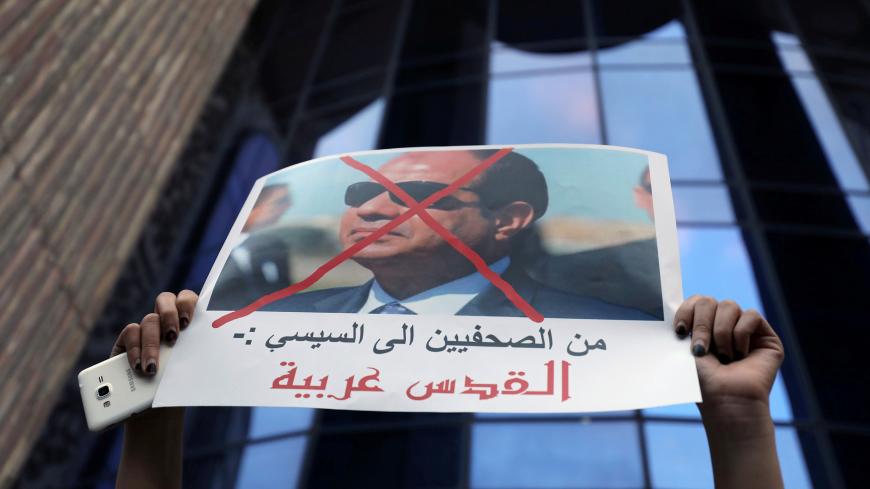 A demonstrator holds up a sign at a protest against U.S. President Donald Trump's Jerusalem declaration, that reads "From the journalists to Sisi: Jerusalem is Arab" in front of the Syndicate of Journalists in Cairo, Egypt December 7, 2017. REUTERS/Mohamed Abd El Ghany - RC1FEABD05A0