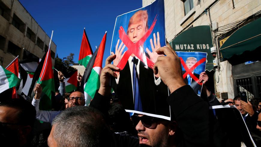 Palestinian protestors hold Palestinian flags and pictures of U.S. President Donald Trump during a demonstration in a street in east Jerusalem December 9, 2017 REUTERS/Ammar Awad - RC1136B72E10
