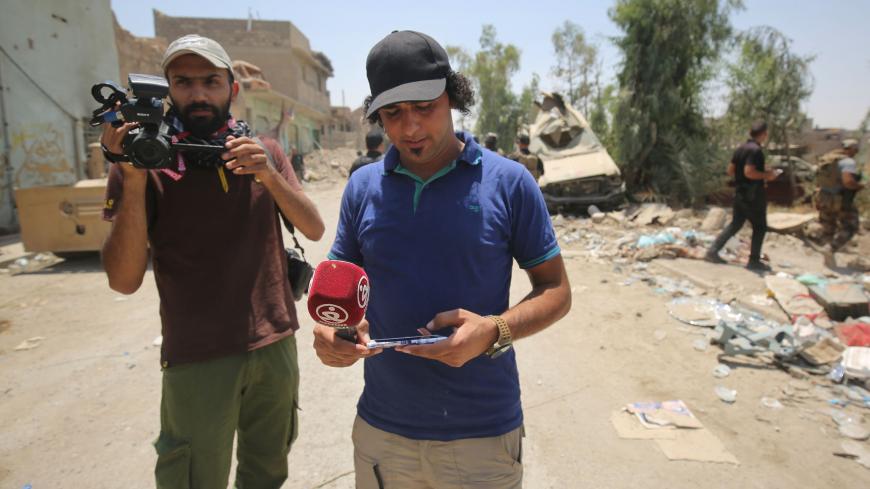 Iraqi journalists are seen covering events in the embattled city of Mosul on June 20, 2017, during the ongoing offensive by Iraqi forces to retake the last district of the city still held by the Islamic State group. 
The death of two journalists in Mosul has highlighted once more the particular dangers of covering the battle to recapture the Iraqi city from Islamic State group fighters. Covering the battle for Mosul, especially in the narrow streets of the Old City, where the last jihadists are holed up, is