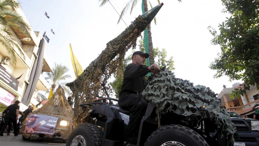 A Hezbollah member drives a 4-wheel motorbike mounted with a mock rocket during a re-enactment of the battle of Kerbala during a mourning process, ahead of the day of Ashura, in Saksakieh village, southern Lebanon, October 18, 2015. Ashoura, the most important day in the Shi'ite calendar, commemorates the death of Imam Hussein, grandson of the Prophet Mohammad, in the 7th century battle of Kerbala. REUTERS/Ali Hashisho  - GF10000249852