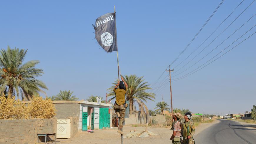 Iraqi army soldiers take down an Islamic State flag in the town of Hit in Anbar province, Iraq October 10, 2016. Picture taken October 10 2016. REUTERS/Stringer     TPX IMAGES OF THE DAY      - S1BEUGLUULAA
