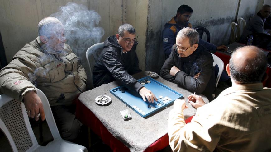 Palestinian people play a game of backgammon at a cafe in the Baladiyat neighbourhood of Baghdad January 30, 2016. Picture taken January 30, 2016.  REUTERS/Khalid al Mousily - GF10000320011