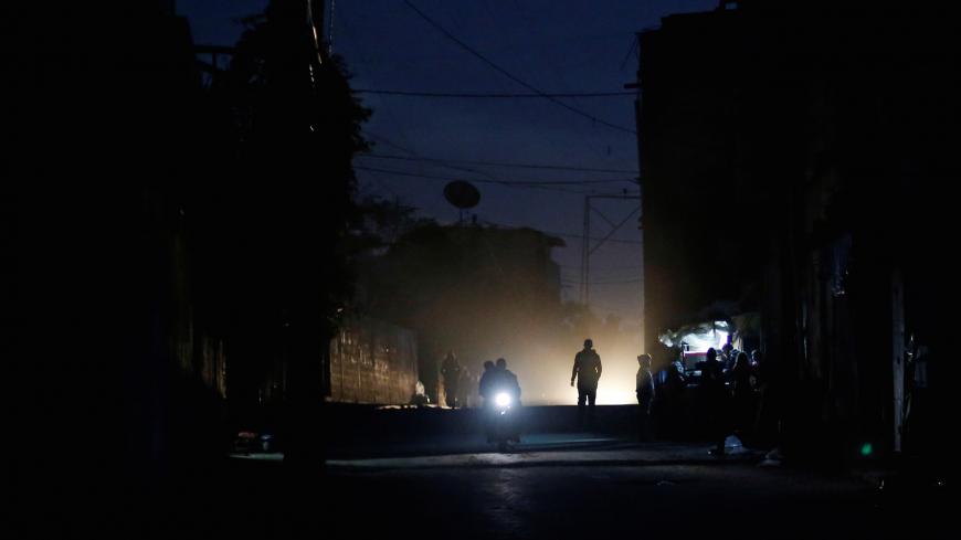 Palestinians ride a motorcycle during a power cut on a street in Beit Lahiya in the northern Gaza Strip January 11, 2017. Picture taken January 11, 2017. REUTERS/Mohammed Salem - RC1567C8AF00