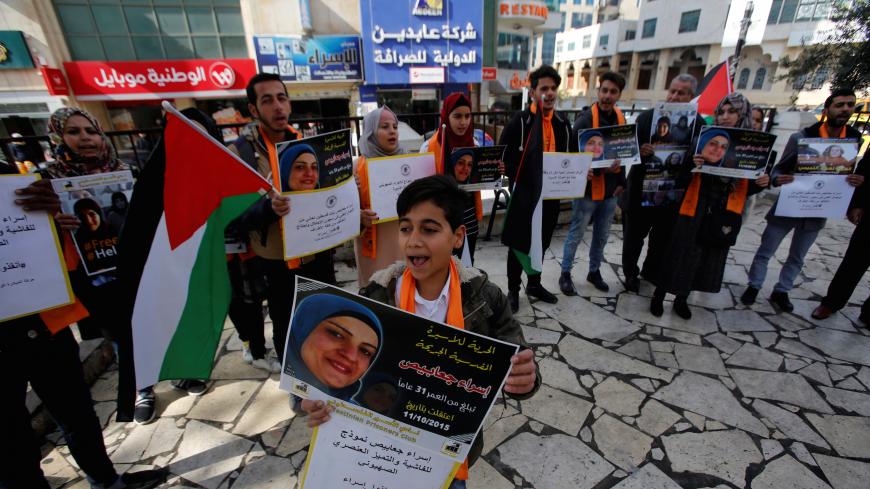 A boy holds a picture of female Palestinian prisoner Israa Jabees during a rally calling on Israel to release her, in the West Bank city of Hebron January 16, 2018. REUTERS/Mussa Qawasma - RC19BF2EB890