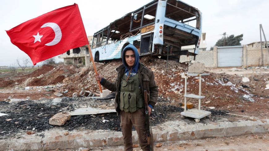 A Turkey-backed Free Syrian Army fighter holds a makeshift Turkish flag as he patrols on a road near Azaz, Syria January 21, 2018. REUTERS/Osman Orsal - RC12DBB08A80