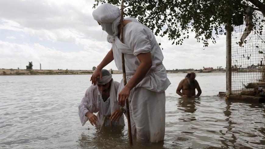 A Mandaean priest baptises a worshipper in the Tigris river during the Benja festival in Baghdad March 16, 2016.  REUTERS/Ahmed Saad - GF10000347584