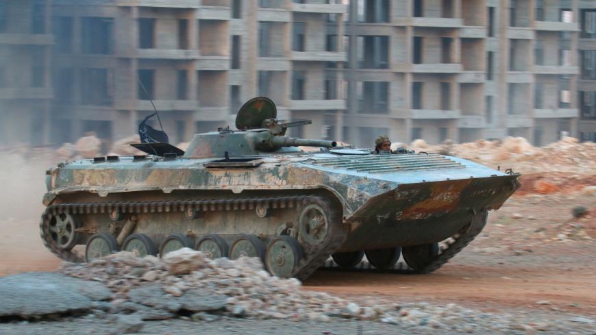 A fighter of the Syrian Islamist rebel group Jabhat Fateh al-Sham, the former al Qaeda-affiliated Nusra Front, rides in an armoured vehicle in the 1070 Apartment Project area in southwestern Aleppo, Syria August 5, 2016. REUTERS/Ammar Abdullah - S1BETTTBXDAC