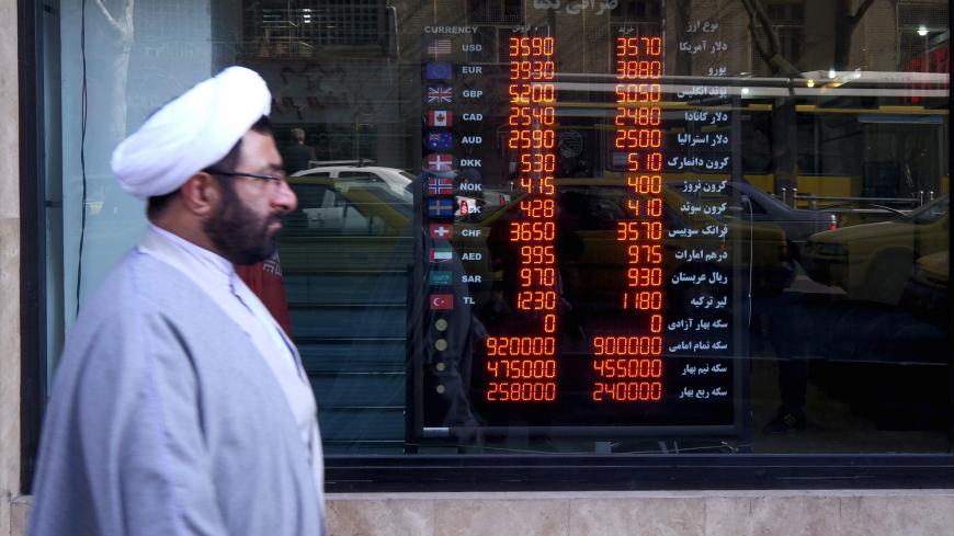 A cleric walks past a currency exchange shop in Tehran's business district, Iran, January 17, 2016. REUTERS/Raheb Homavandi/TIMAATTENTION EDITORS - THIS IMAGE WAS PROVIDED BY A THIRD PARTY. FOR EDITORIAL USE ONLY. - GF20000097644