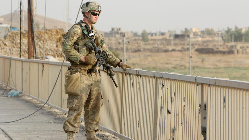 A U.S soldier stands on a bridge with his gun in the town of Gwer northern Iraq  August 31, 2016. Picture taken August 31, 2016. REUTERS/Azad Lashkari - S1AETYVKSRAA