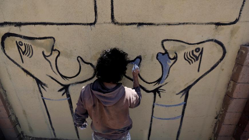 Artist and activist Murad Subai paints graffiti on a wall in Sanaa, Yemen March 15, 2017. REUTERS/Khaled Abdullah - RC169DE2DB60
