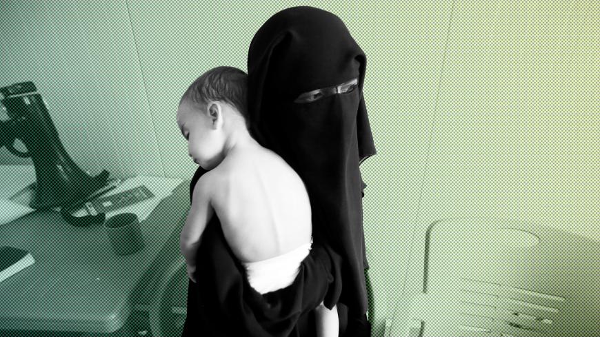 A foreign wife of Islamic State militants holds her child at Hammam Al-Alil camp in south of Mosul, Iraq September 13, 2017. Picture taken September 13, 2017. REUTERS/Azad Lashkari - RC1F166AB320