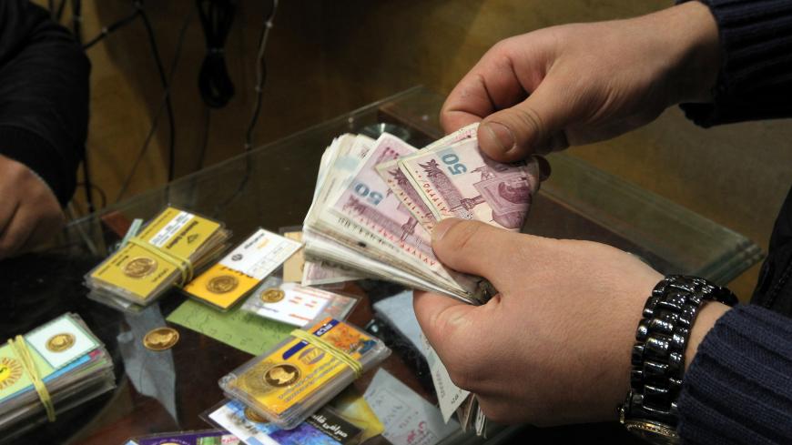 An Iranian man counts banknotes after exchanging a gold coin for cash in Tehran on January 23, 2012. Gold coins were being exchanged for over 10,000,000 rials as the Iranian currency continued to lose value against the US dollar. Top European Union diplomats are meeting in Brussels to tighten existing sanctions on Iran by banning imports of Iranian crude as well as targeting finance, petrochemicals and gold to pressure the country. AFP PHOTO/ATTA KENARE (Photo credit should read ATTA KENARE/AFP/Getty Images