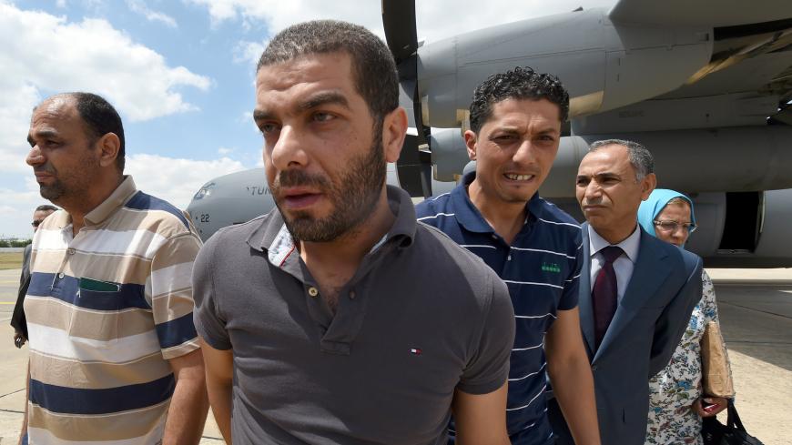 Tunisian officials kidnapped by armed militia at the Tunisian Consulate in the Libyan captial, Tripoli, arrive at Aouina military airport in Tunis on June 19, 2015, following a week-long captivity. Tunisia said it was shutting its consulate in conflict-hit Libya as the 10 staffers who were abducted were released and heading home. AFP PHOTO / FETHI BELAID        (Photo credit should read FETHI BELAID/AFP/Getty Images)