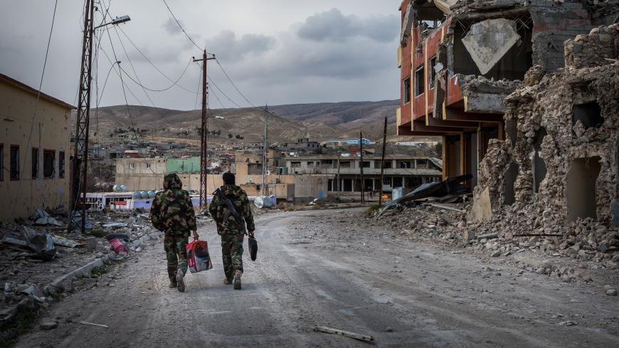 25 Jan 2016 - Sinjar, Iraq. Kurds Peshmerga walks through the ruins of the city which had a mixed population of yazidi and muslims kurds. The city has been invaded by ISIS/Daesh on the 3rd of August 2014. Sinjar has been officially liberated in November 2015 cutting the road used by the jhiadi group as a supply route between Raqqah and Mosul. The city is today a ghost town inhabited almost only by military groups such as Kurds Peshmerga, PKK, Iraqi Police and YBS (Yazidi Sinjar Resistance Units). At present