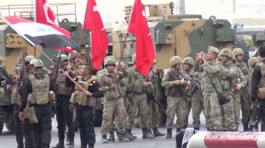 Iraqi and Turkish soldiers wave flags at the Habur Border Gate between Turkey and Iraq in this still image taken from video, October 31, 2017. IHA/ via REUTERS   ATTENTION EDITORS - THIS IMAGE HAS BEEN SUPPLIED BY A THIRD PARTY. TURKEY OUT. NO COMMERCIAL OR EDITORIAL SALES IN TURKEY. PART NO ACCESS TURKEY.? - RC19E8A7C400
