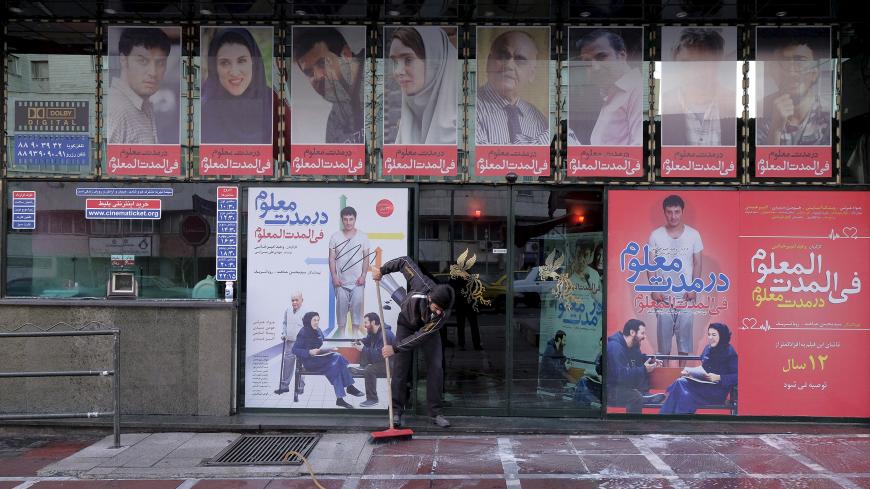 A worker cleans a sidewalk in front of a local cinema in central Tehran January 16, 2016. REUTERS/Raheb Homavandi/TIMA  ATTENTION EDITORS - THIS IMAGE WAS PROVIDED BY A THIRD PARTY. FOR EDITORIAL USE ONLY.   - GF20000096748