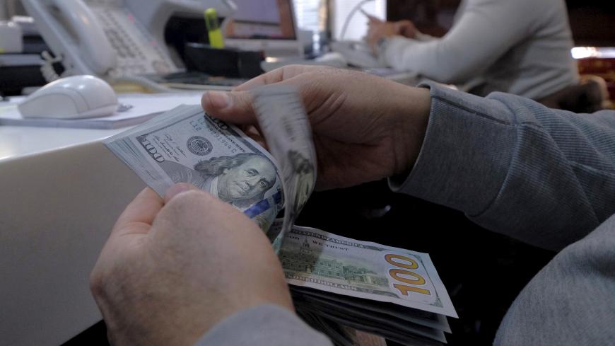 A money changer counts out U.S. dollars for a customer in Tehran's business district, Iran, January 20, 2016. REUTERS/Raheb Homavandi/TIMA  ATTENTION EDITORS - THIS IMAGE WAS PROVIDED BY A THIRD PARTY. FOR EDITORIAL USE ONLY.   - GF20000100972
