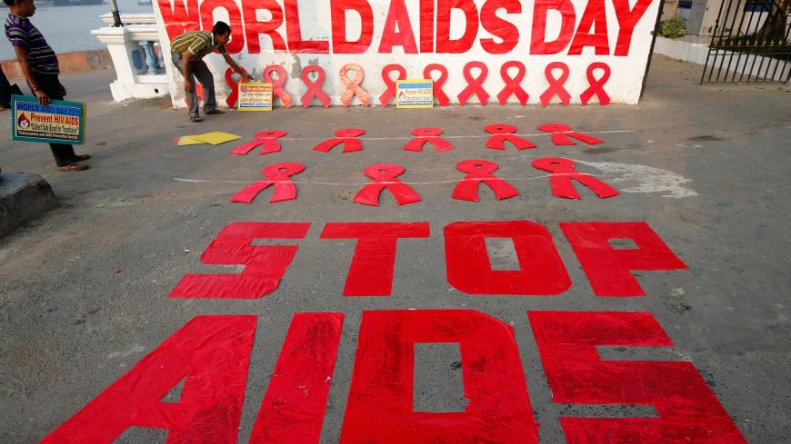 A man places a placard as he prepares a message during an HIV/AIDS awareness campaign on the eve of World AIDS Day in Kolkata, India, November 30, 2017. REUTERS/Rupak De Chowdhuri - RC1104607C00