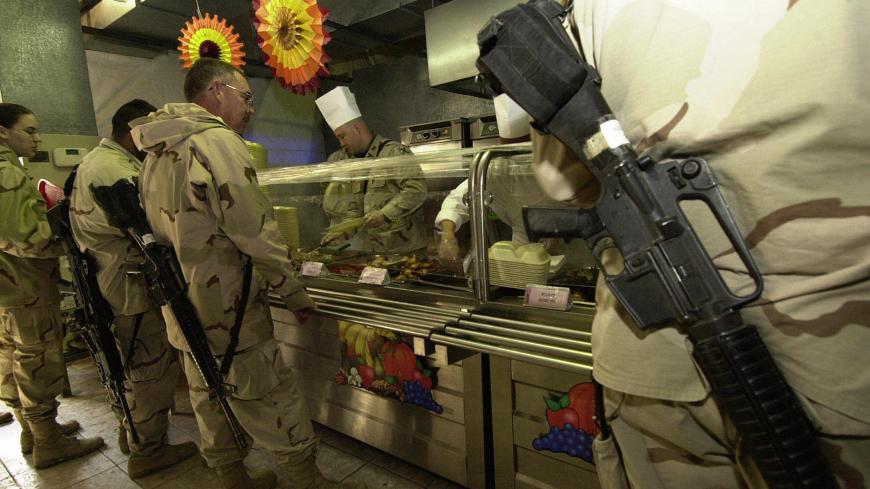 MOSUL, IRAQ:  (FILES)-A US officer from the 1st  Brigade, 25th Infantry Division (Stryker Brigade Combat Team) serves turkey for soldiers lining up for a traditional Thanksgiving meal at a dinning room in a US base in the northern Iraqi city of Mosul, 25 November 2004. A huge explosion at this US army mess hall killed 22 people in the deadliest single attack against US forces in Iraq yesterday 21 December 2004.   AFP PHOTO/TAUSEEF MUSTAFA  (Photo credit should read TAUSEEF MUSTAFA/AFP/Getty Images)