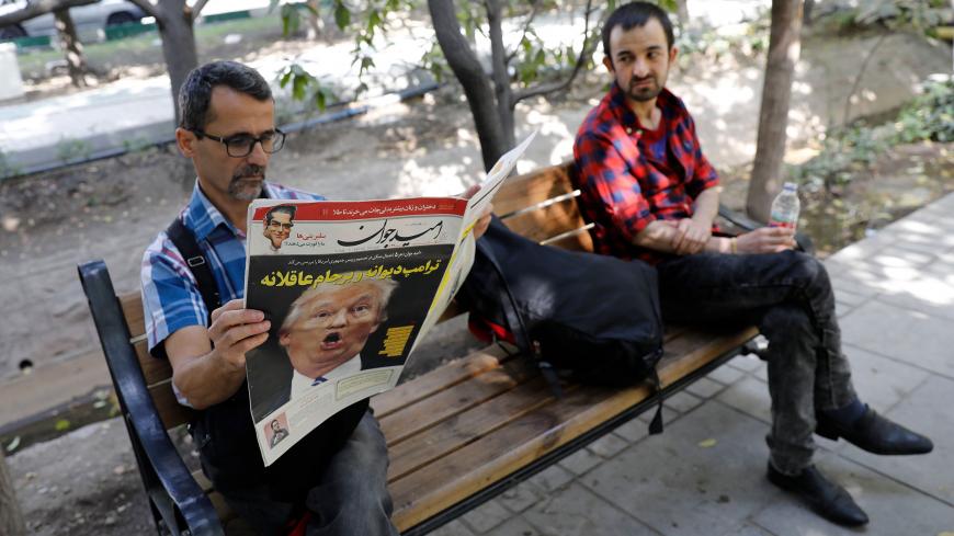 An Iranian man reads a copy of the daily newspaper 'Omid Javan' bearing a picture of US President Donald Trump with a headline that reads in Persian "Crazy Trump and logical JCPOA (Joint Comprehensive Plan of Action)", on October 14, 2017, in front of a kiosk in the capital Tehran.
Iranians responded with anger and mockery to the bellicose criticism of their government by US President Donald Trump who threatened to tear up the landmark nuclear deal.
 / AFP PHOTO / STR        (Photo credit should read STR/AF
