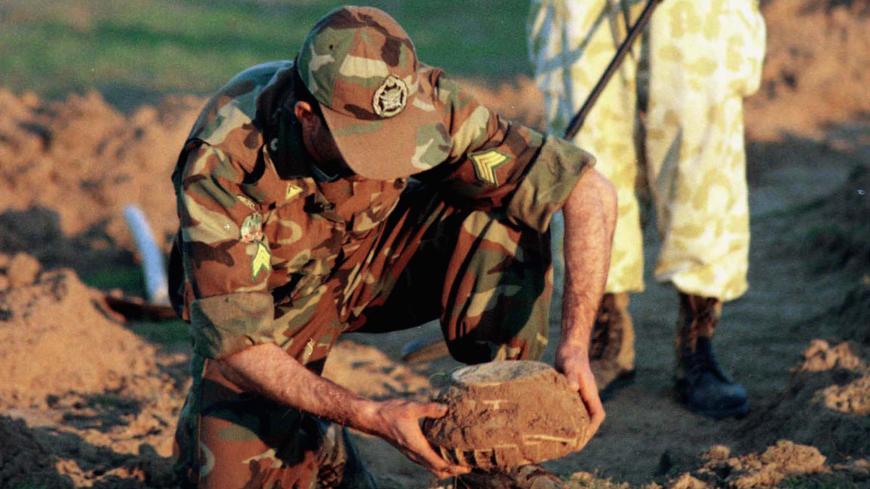 Iranian soldiers recover an unexploded anti tank mine, January 21, 2001, left over from the 1980-1988 war with Iraq using a metal detector and spike but no protective clothing. Iran and Iraq declared a cease-fire, but have not signed a formal peace treaty, therefore, Iran does not have access to maps of the minefields laid by retreating Iraqi forces. Army officials estimate that of 1,800,000 hectares of Iran's border with Iraq which was mined, 700,000 hectares have been cleared with no international assista