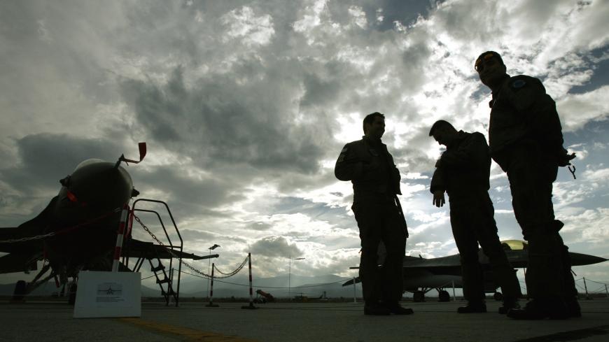Greek Air force pilots stand on the tarmac by F-16 Falcon fighting aircrafts in Nea Anchialos air force base some 300 km north of Athens November 8, 2004. Greek air force bases where open to the public on Monday as part of celebrations for the day of Archangel Michael, protector of the Greek air force. REUTER/Yannis Behrakis  YB/THI - RP5DRHXPMGAC
