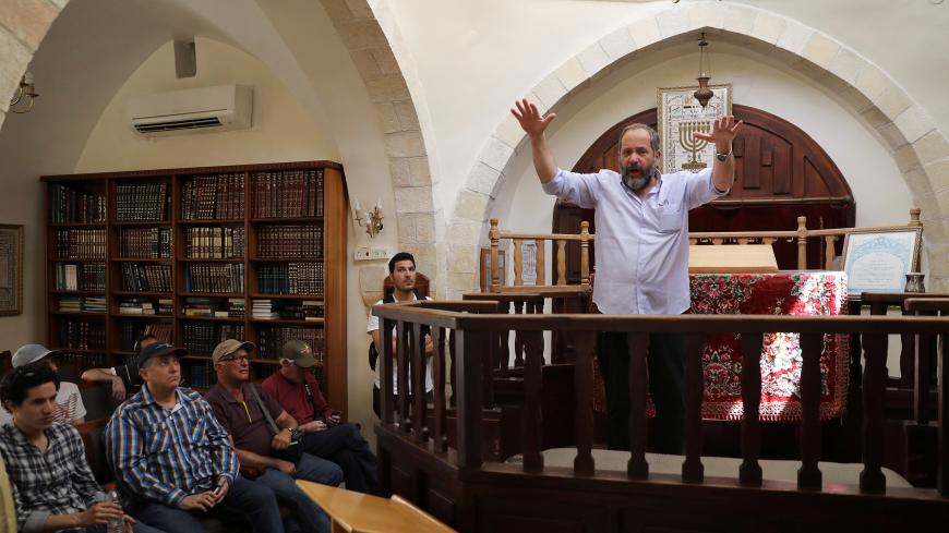 Spokesperson of the Jewish settlement located inside Hebron, Noam Arnon, gestures as he speaks to visitors on a tour held by far-right group "Im Tirzu" in a synagogue in the West Bank city of Hebron May 8, 2017. Picture taken May 8, 2017. REUTERS/Ronen Zvulun - RC1AAFA888F0